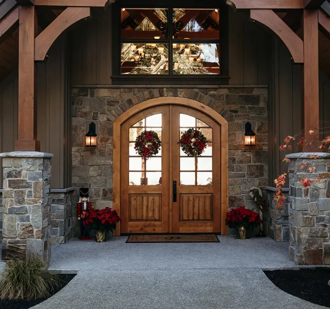 Double arch door with v-groove panels in Knotty Alder featured on the exterior of the home.