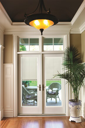Patio with wood exterior french doors and transoms