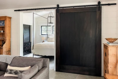 Walnut monster door on barn track leading to bedroom