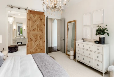 Knotty alder barn style door on barn track leading to master bedroom